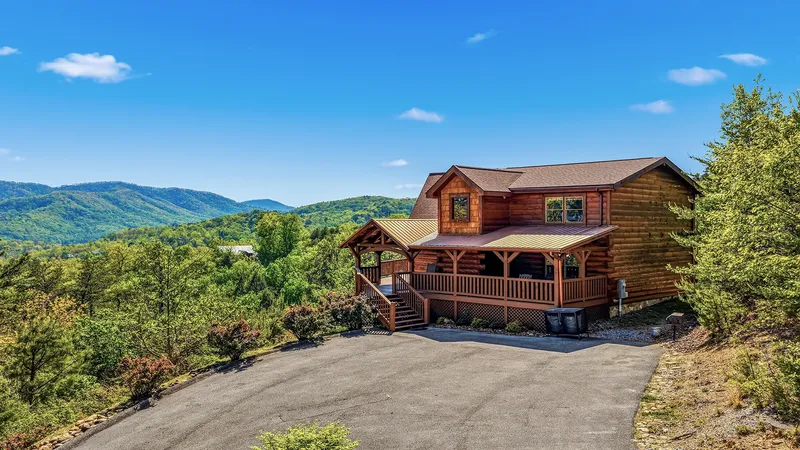 The log cabin and wraparound porch from the drive on a clear day