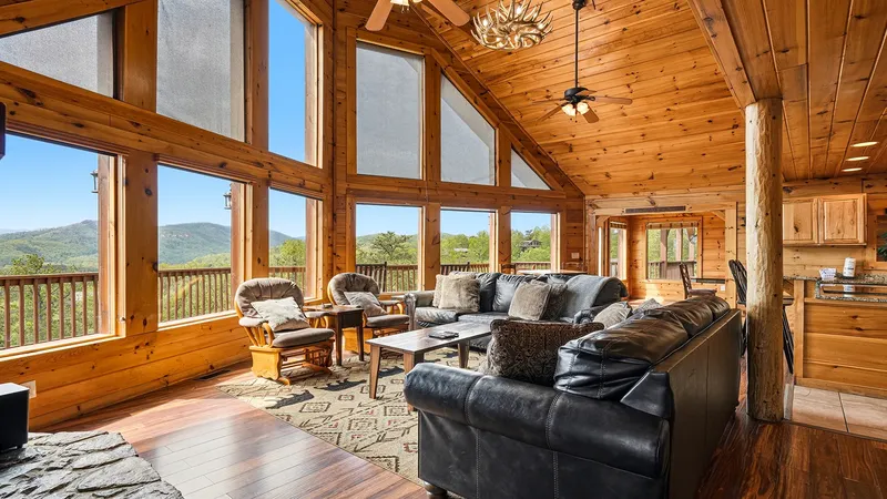 Great room with cathedral ceiling, leather sofas, and a wall of windows to the ridge